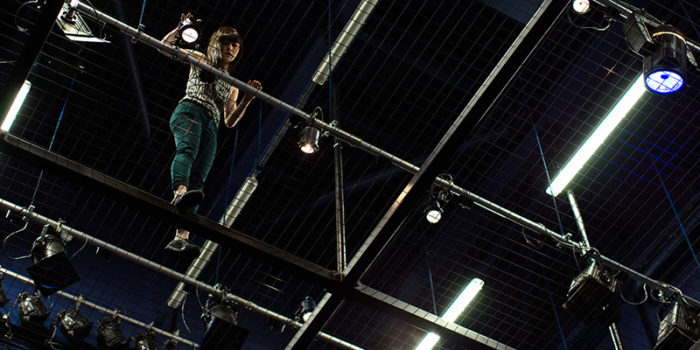 A person on a theatre tension grip up high.
